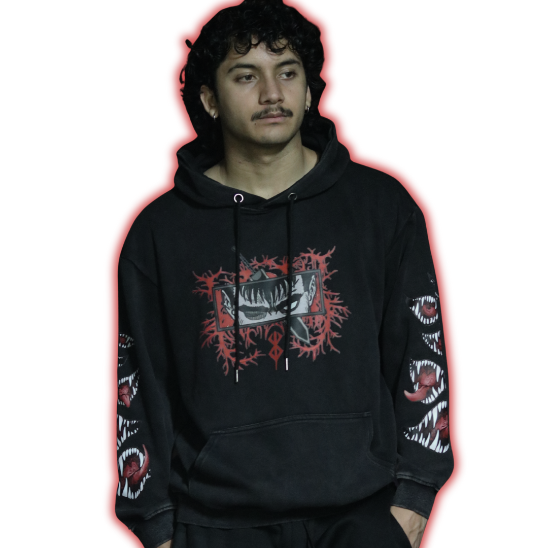 Person wearing a black hoodie with graphic designs on sleeves and chest
