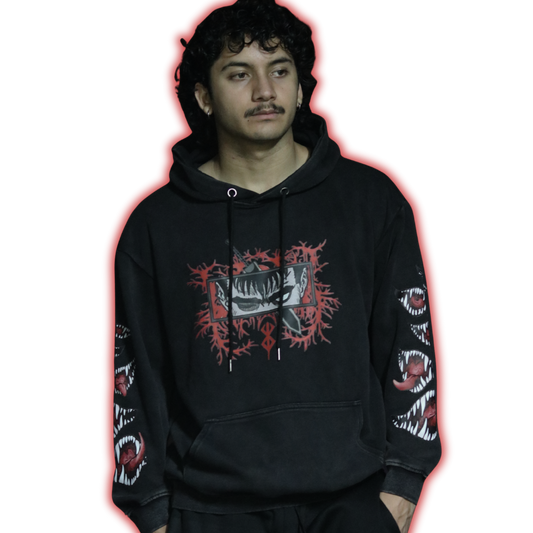 Person wearing a black hoodie with graphic designs on sleeves and chest