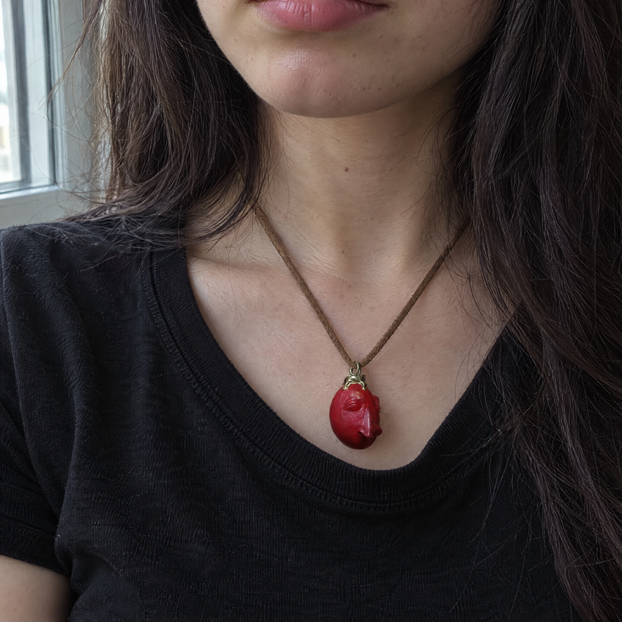 Behelit necklace worn with a black t-shirt